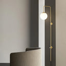 minimalist brass wall light with white glass