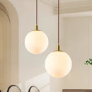Modern minimalist brass pendant light with luminous orb