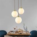 Minimalist brass pendant light with milky glass orb