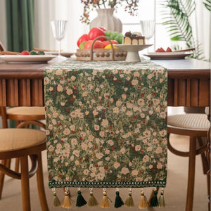 Green jacquard table runner with floral pattern and tassels