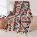 Plaid tricot motif geometrique boheme avec pompons doux