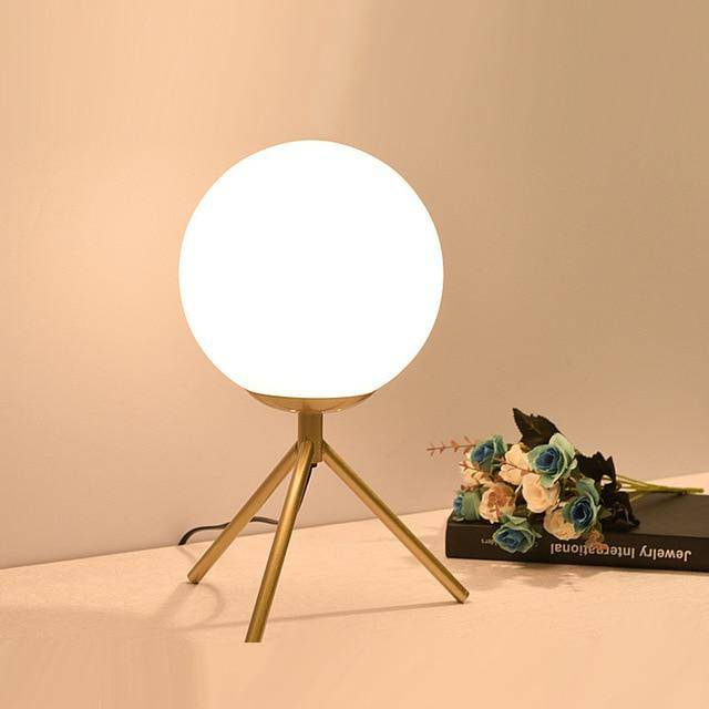 Lampe à poser design à bras dorés et boule en verre