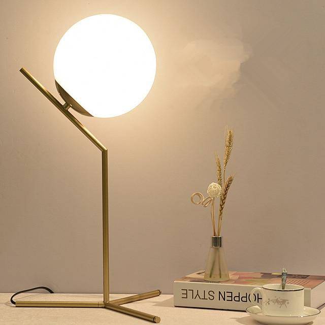Lampe à poser design à bras dorés et boule en verre